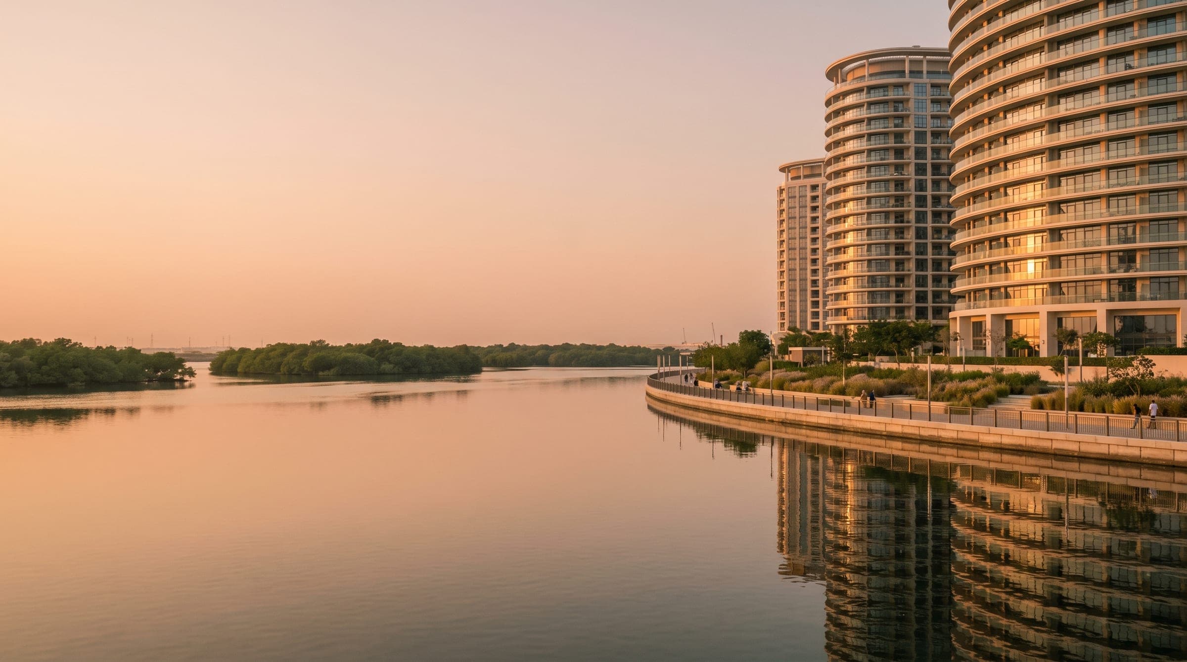 Dubai Creek Harbour waterfront promenade at golden hour with residential towers reflected in the creek