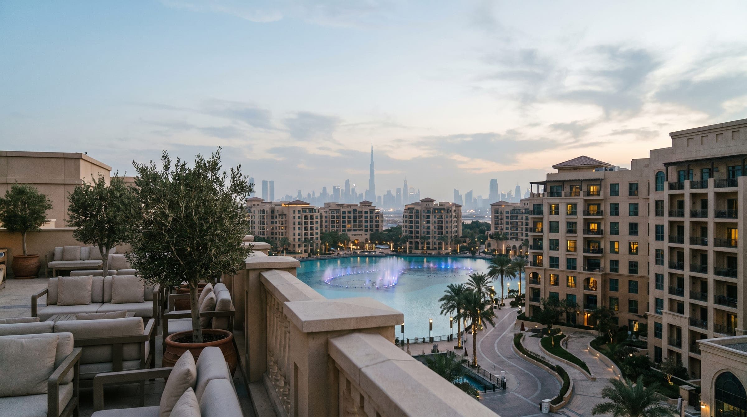 Tree-lined boulevard in Downtown Dubai at golden hour with stone and glass residential facades