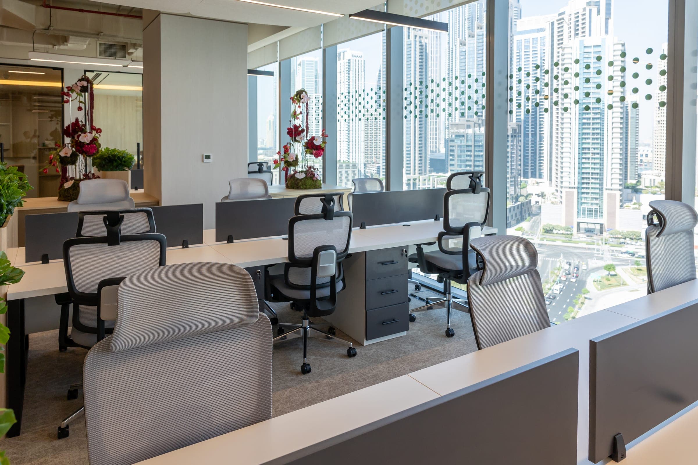 Photograph of workstations in the OAC18 office at The Opus, with neighbouring towers through the windows