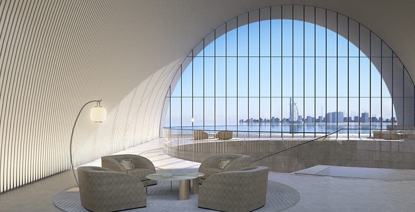Render of a lounge inside Armani Beach Residences at Palm Jumeirah, seating set beneath the arched window with the coastline beyond