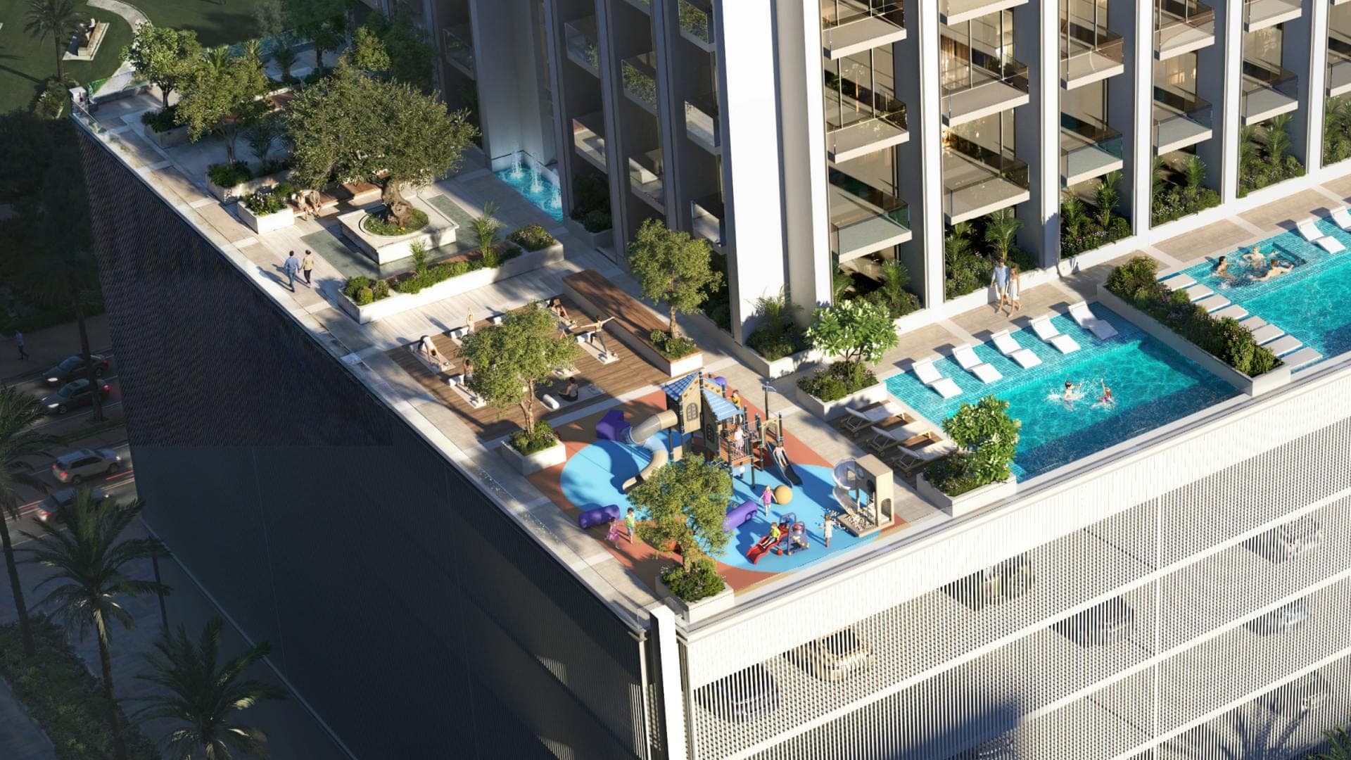 Render of the podium deck at Binghatti Etherea seen from above, with a pool, sun loungers, a children's play area and planted seating