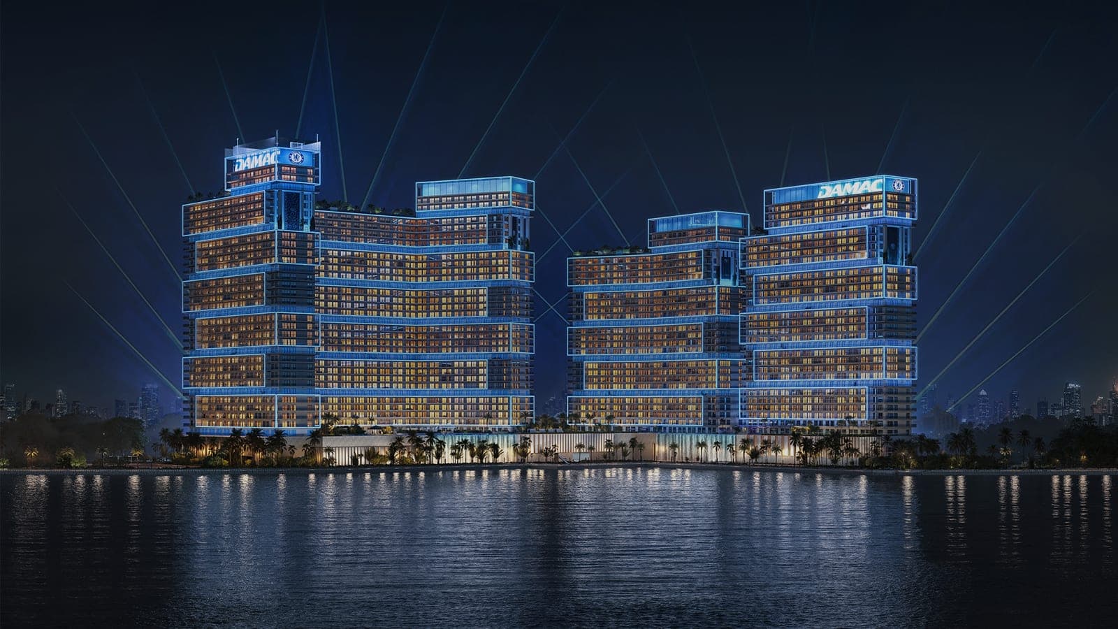 Render of Chelsea Residences by DAMAC lit at night, its stepped blocks seen across the water at Dubai Maritime City