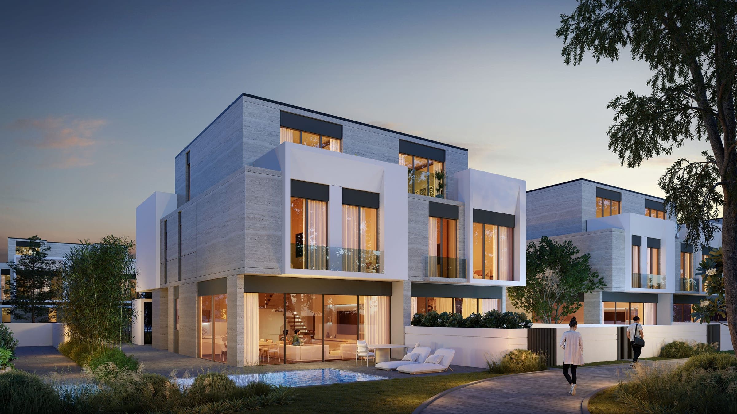 Render of D-Villas at Jumeirah Golf Estates at dusk, lit living rooms opening onto a garden pool beside a curving footpath