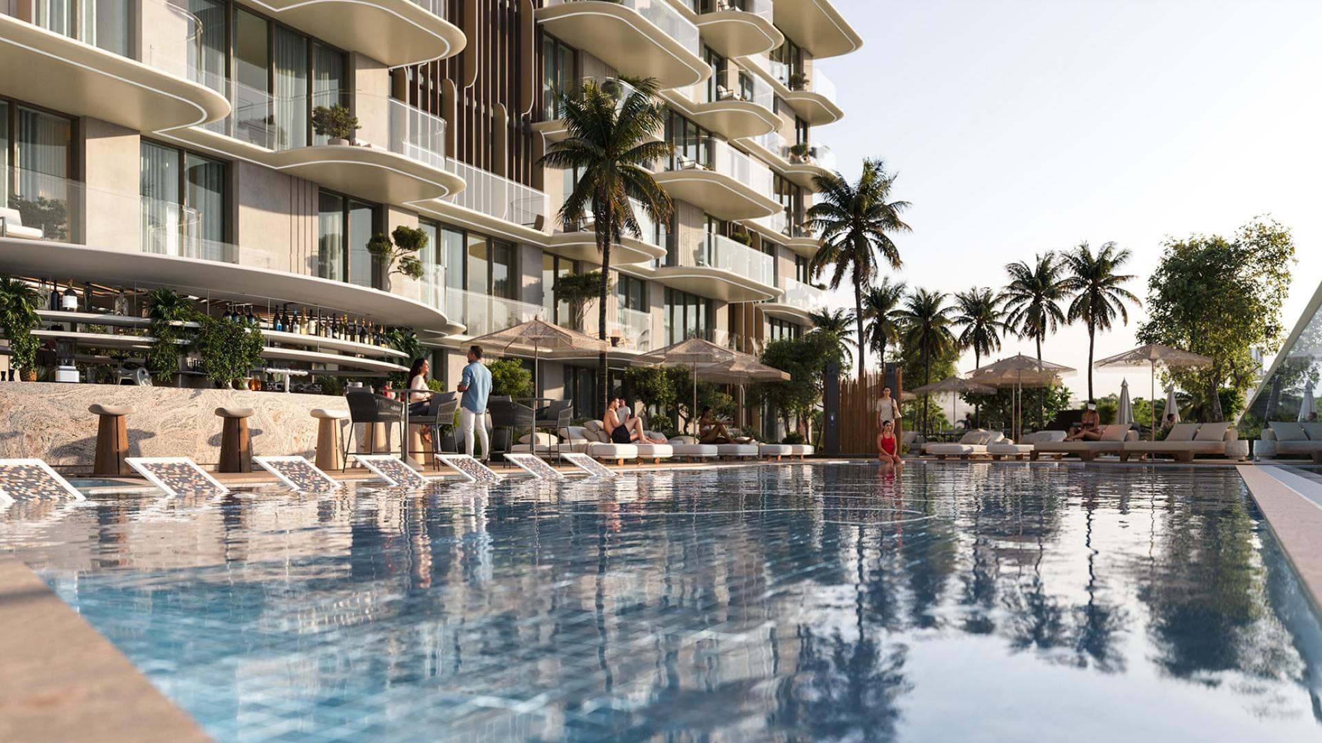Render of the pool deck at SAMANA South Haven, with a bar, loungers and palms along the water below the building's balconies