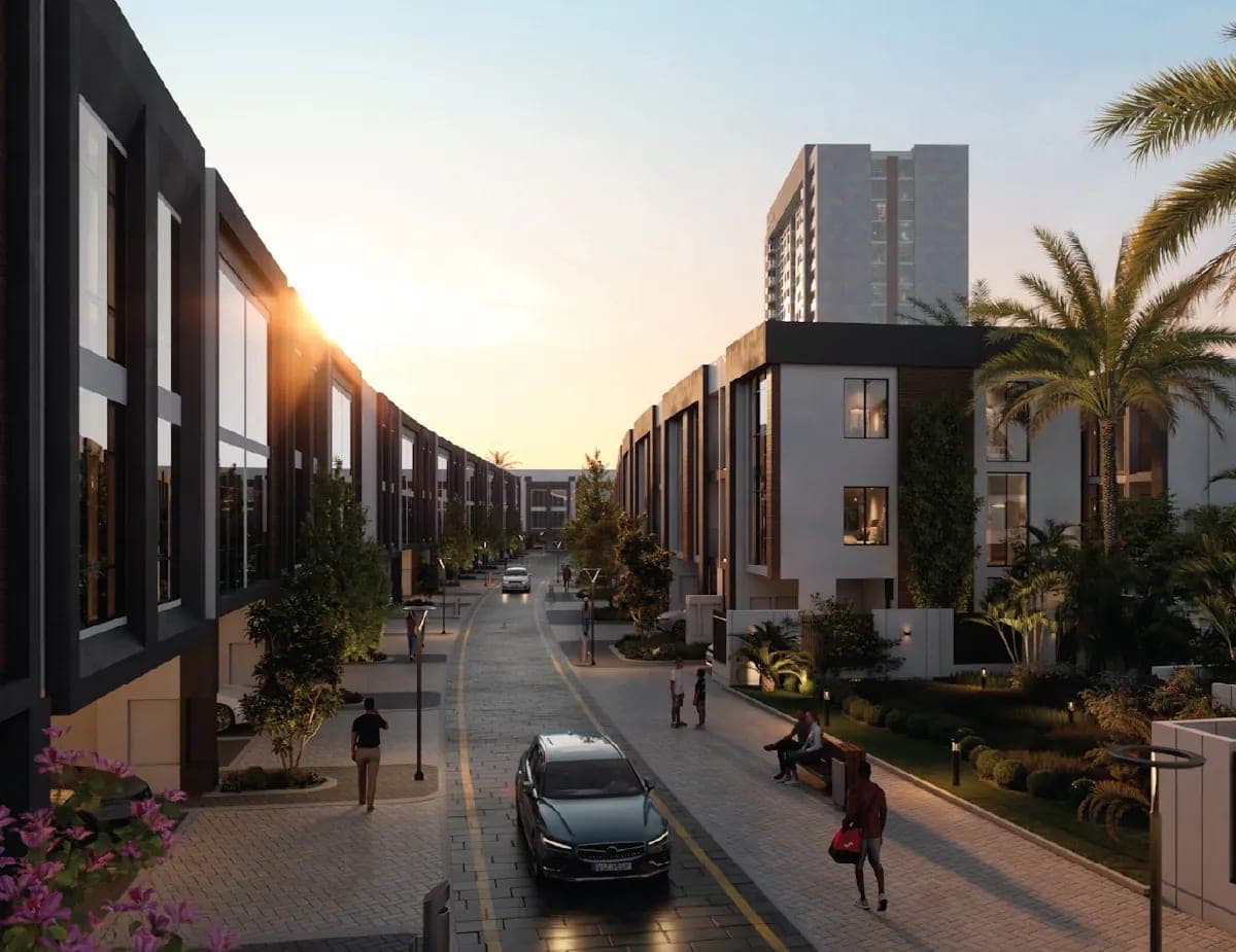 Render of a residential street at Verdana at dusk, townhouse frontages on either side and an apartment tower beyond